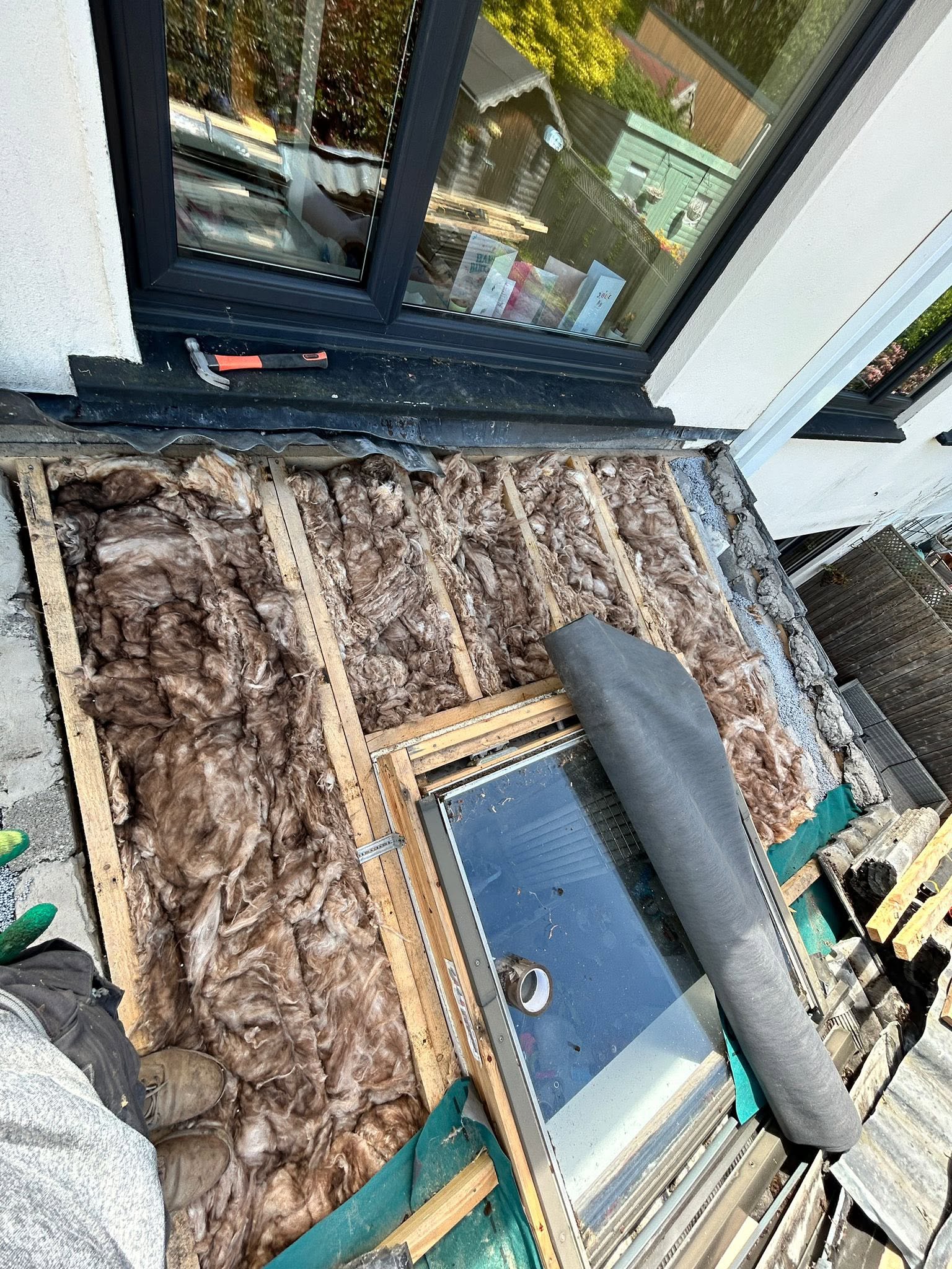 A tile roof with damaged tiles showing insulation underneath in Dublin