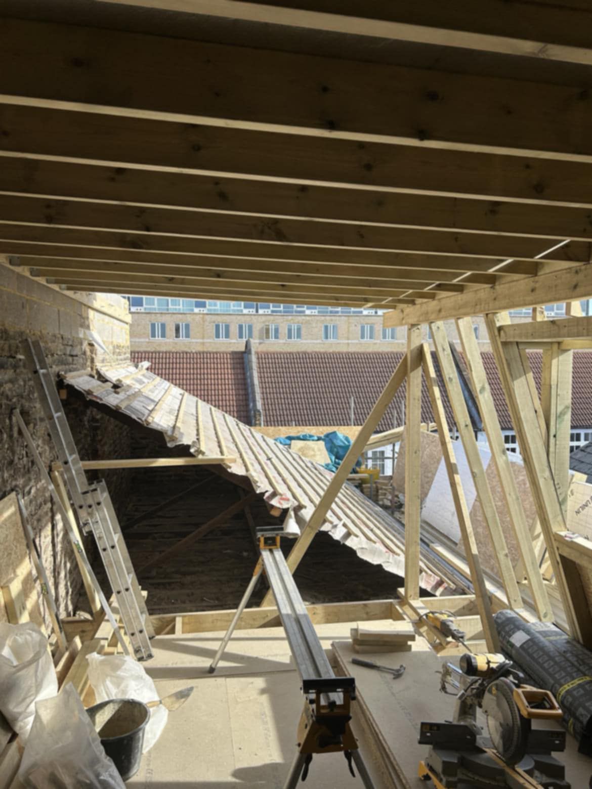 inside of an attic in Dublin with wood and other tools laying around during a roof installation