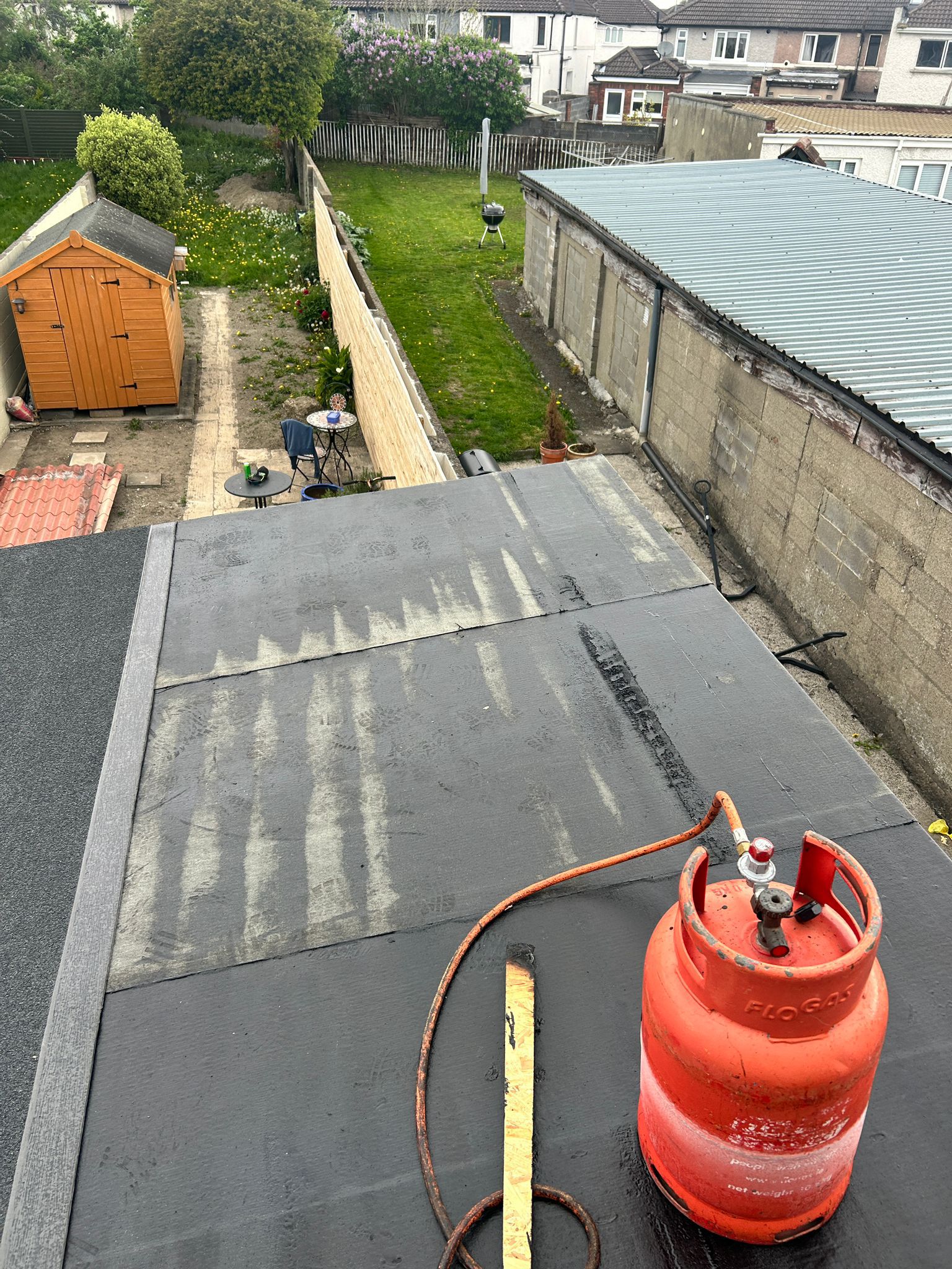 New roof felt being heated with heat gun on a flat roof in Dublin