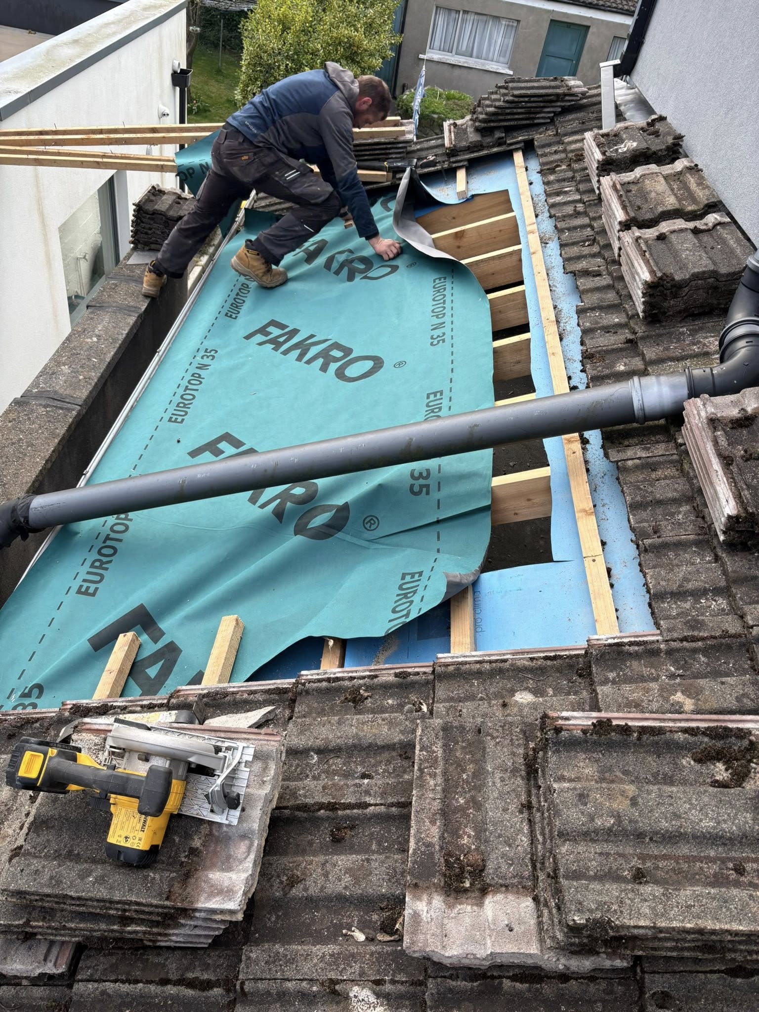 the outside of a house in Dublin with a new roof being installed and scaffolding around the house