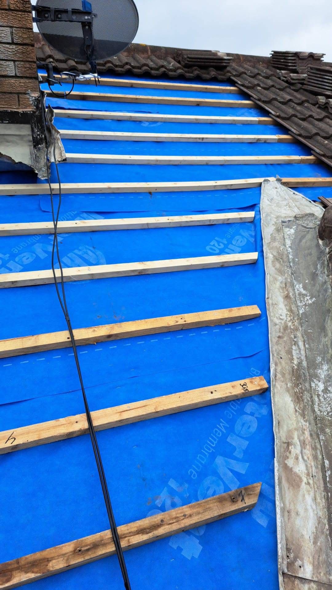 the outside of a house in Dublin with a new roof being installed and scaffolding around the house